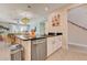 Open-concept kitchen island with stainless steel dishwasher and seating, connecting to the dining and living areas at 7458 Gathering Dr, Kissimmee, FL 34747