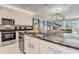 Well-equipped kitchen with stainless steel appliances, dark countertops, and barstool seating overlooking the dining area at 7458 Gathering Dr, Kissimmee, FL 34747