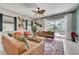 Cozy living room with stylish furnishings, ceiling fan, and sliding doors to the patio and pool at 7458 Gathering Dr, Kissimmee, FL 34747