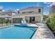 Stunning backyard pool and patio area with modern outdoor furniture, perfect for relaxation and entertainment at 7458 Gathering Dr, Kissimmee, FL 34747