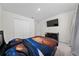 Well lit bedroom with gray carpet, double door closet, and mounted flat screen television at 761 Parrot Ct, Kissimmee, FL 34759