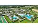 An aerial view featuring a community pool, clubhouse, tennis and bocce ball courts, and a well-manicured golf course at 7834 Stoney Bay Loop, Kissimmee, FL 34747