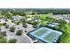 Aerial view displays a community pool, clubhouse, tennis courts, and parking near a beautiful golf course at 7834 Stoney Bay Loop, Kissimmee, FL 34747