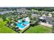 An aerial shot highlighting the beautiful community pool, clubhouse, and tennis courts, set among lush landscaping at 7834 Stoney Bay Loop, Kissimmee, FL 34747