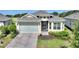 Charming single-story home featuring a two-car garage, brick paved drive, and manicured landscaping at 7834 Stoney Bay Loop, Kissimmee, FL 34747