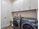 Practical laundry room with modern washer and dryer, storage cabinets, and convenient sink at 7834 Stoney Bay Loop, Kissimmee, FL 34747