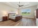 Bright main bedroom with tray ceilings, large windows overlooking golf course and hardwood floors at 7834 Stoney Bay Loop, Kissimmee, FL 34747