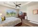 Spacious main bedroom with tray ceilings, large window overlooking golf course and hardwood floors at 7834 Stoney Bay Loop, Kissimmee, FL 34747