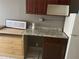 Kitchenette shows a granite countertop, a refrigerator, and dark wooden cabinets at 7900 S Orange Blossom Trl # 2136, Orlando, FL 32809