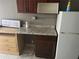 Kitchenette shows a granite countertop, a refrigerator, and dark wooden cabinets at 7900 S Orange Blossom Trl # 2136, Orlando, FL 32809