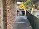 Exterior walkway with brick wall and view of other units surrounded by lush, tropical vegetation and black iron fencing at 7900 S Orange Blossom Trl # 2136, Orlando, FL 32809