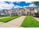 Townhome showcasing a driveway, landscaping, and an inviting facade at 8112 Princess Palm Ln, Kissimmee, FL 34747