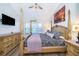 Spacious main bedroom featuring a four-post bed, ceiling fan and a mounted TV at 8112 Princess Palm Ln, Kissimmee, FL 34747