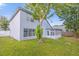 The backyard shows a home exterior, a well-kept lawn and surrounding trees and blue skies at 10957 Norcross Cir, Orlando, FL 32825