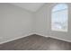 The empty room has a large window for natural light and features hard wood floors and light-colored walls at 10957 Norcross Cir, Orlando, FL 32825