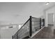 Second floor staircase landing with decorative iron railing and plank floors at 10957 Norcross Cir, Orlando, FL 32825