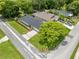 An aerial view showcases the home's lush landscaping and spacious front yard, complemented by a long driveway and a black roof at 1501 Delaware Ave, St Cloud, FL 34769