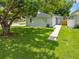 Charming home with a well-maintained lawn, mature tree, and a welcoming walkway leading to the front door at 1501 Delaware Ave, St Cloud, FL 34769