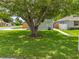 A mature shade tree creates a serene setting for this home with a walkway leading to the front door at 1501 Delaware Ave, St Cloud, FL 34769