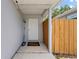 The covered front porch, featuring a neutral colored front door, offering a shaded entryway and a welcome mat at 1501 Delaware Ave, St Cloud, FL 34769