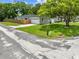 A well-manicured front yard features lush grass, a mature tree, and a driveway leading to the garage, enhancing curb appeal at 1501 Delaware Ave, St Cloud, FL 34769