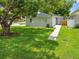 Well-maintained front lawn leading up to a cozy single-story home, shaded by a mature tree at 1501 Delaware Ave, St Cloud, FL 34769