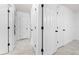 Hallway featuring white doors, black hardware, and neutral tile flooring at 1501 Delaware Ave, St Cloud, FL 34769