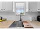 Close-up of a modern kitchen sink with butcher block countertops and white subway tile backsplash at 1501 Delaware Ave, St Cloud, FL 34769