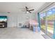 Bright living room featuring tile floors, fan, sliding glass doors, and play area at 1501 Delaware Ave, St Cloud, FL 34769