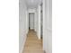 Long, brightly lit hallway featuring wood-look floors and white-painted walls and doors at 2806 Bonneville Dr, Orlando, FL 32826