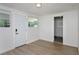 Well-lit room with wood-look flooring, beadboard paneling, and a door leading to another room at 2806 Bonneville Dr, Orlando, FL 32826