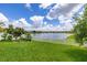 Well-manicured lawn with a white picket fence overlooking a serene lake at 2823 Sail Breeze Way, Kissimmee, FL 34744