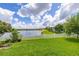 Scenic backyard with a lush lawn and picturesque lake views at 2823 Sail Breeze Way, Kissimmee, FL 34744