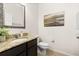 Powder room featuring a granite vanity, decorative mirror, and tile flooring at 2823 Sail Breeze Way, Kissimmee, FL 34744