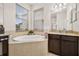 Bathroom with granite countertops, dark wood cabinets and a soaking tub with tile surround at 2823 Sail Breeze Way, Kissimmee, FL 34744