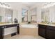 Bathroom with a soaking tub, granite countertops, and dark wood cabinetry at 2823 Sail Breeze Way, Kissimmee, FL 34744