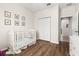 Bright Bedroom with hardwood flooring, a white crib, and a closet with white doors at 2823 Sail Breeze Way, Kissimmee, FL 34744