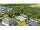 Aerial view of community pool, clubhouse, and nearby homes surrounded by mature trees at 2823 Sail Breeze Way, Kissimmee, FL 34744