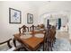 Open dining room with a large wooden table and blue patterned rug at 2823 Sail Breeze Way, Kissimmee, FL 34744
