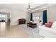 Bright living room with white sofas, a piano, tile flooring, and sliding glass doors at 2823 Sail Breeze Way, Kissimmee, FL 34744