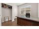 Home office featuring a large, dark-wood desk, hardwood flooring, and built-in shelving at 2823 Sail Breeze Way, Kissimmee, FL 34744
