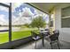 Screened-in patio with seating and a view of the landscaped backyard and tranquil pond at 2823 Sail Breeze Way, Kissimmee, FL 34744