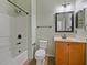 Bathroom featuring a shower-tub combo and a vanity with honey-colored cabinets at 2829 Shelburne Way, St Cloud, FL 34772