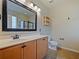 Bathroom features a vanity with honey-colored cabinets and a large mirror, plus a toilet at 2829 Shelburne Way, St Cloud, FL 34772