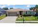 Charming single Gathering home featuring a two-car garage and well manicured lawn with shrubbery at 2829 Shelburne Way, St Cloud, FL 34772