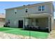 Spacious backyard featuring a covered patio with lighting and artificial grass at 3252 Jackson Bluff Way, Clermont, FL 34711