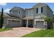 Charming two-story home featuring a brick driveway, two-car garage, and solar panels at 3252 Jackson Bluff Way, Clermont, FL 34711