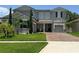 Beautiful home with manicured lawn, brick driveway, stone accents, and lush landscaping at 3252 Jackson Bluff Way, Clermont, FL 34711