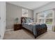 Cozy bedroom featuring a full bed with blue accents, a nightstand, and natural light from window at 4403 Scene Ln, Kissimmee, FL 34746