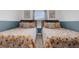 Sunlit bedroom featuring two twin beds adorned with floral-patterned bedding and overhead lighting at 4403 Scene Ln, Kissimmee, FL 34746